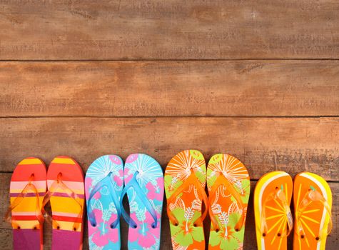 Brightly colored flip-flops on wood 