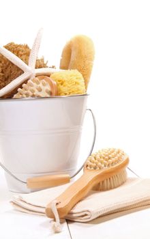 Bucket filled with sponges, scrub brushes and starfish 