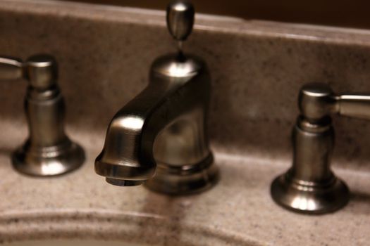 A closeup of a brushed nickel faucet.