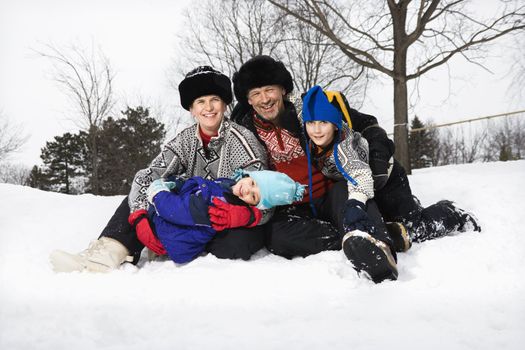 Family sitting in snow.