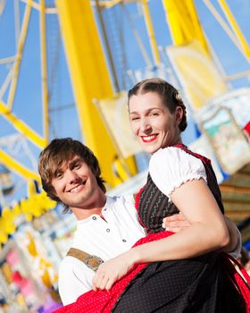 Couple in Tracht flirting at big wheel