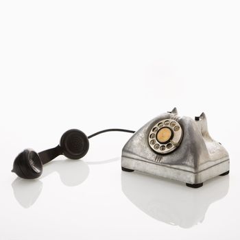 Rotary telephone with reciever to the side.