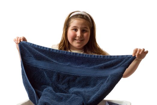 A young girl folding a blue towel, isolated against a white background