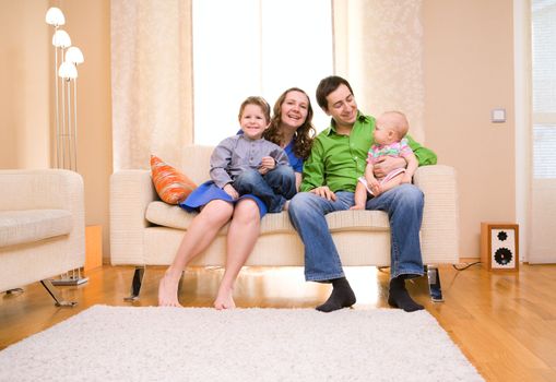 Happy young family of four enjoying time at their home