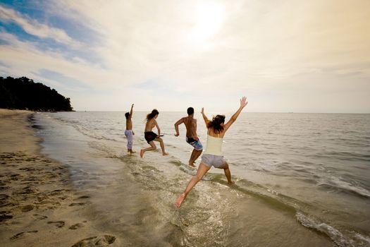 group of friends jumping into the sea