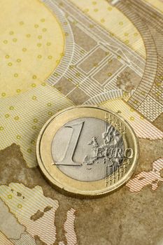 single one euro coin on fifty euro bank note