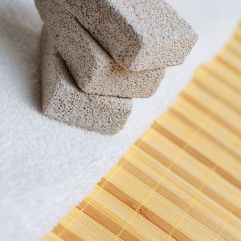 Pumice stones and towel against bamboo reed mat.