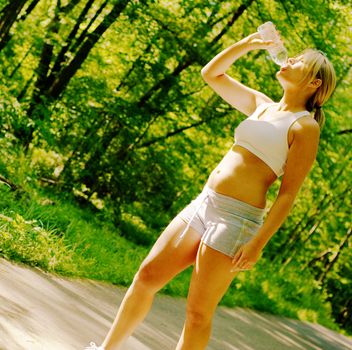 Young woman working out on a forest path.
