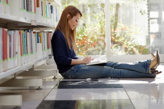 girl studying on floor in library