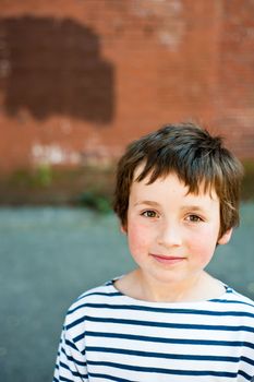 young boy with brick wall behind