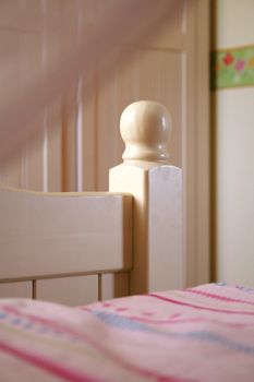 white bed with wooden post and sphere