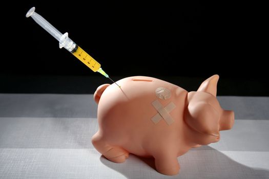 piggy bank with syringe, financial metaphor