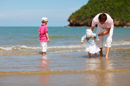Young father with two kids at the beach
