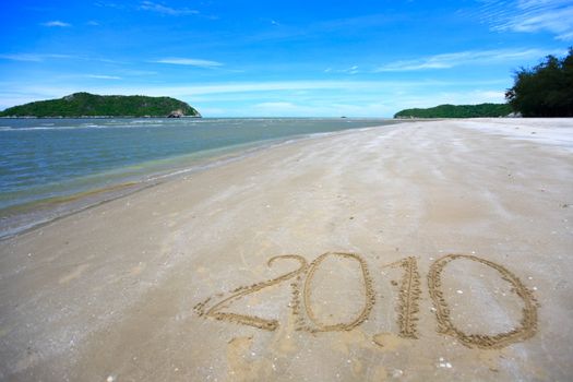 Beautiful tropical beach with number 2010 written on sand