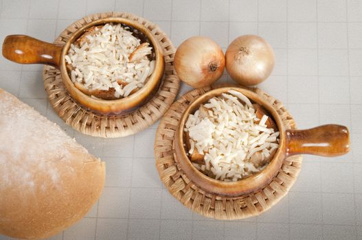 Arrangement of two bowls of onion soup and fresh onions