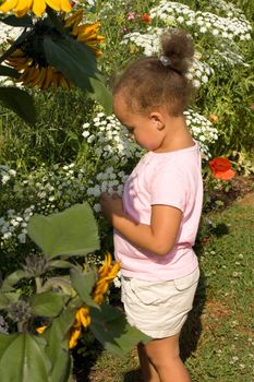 Beautiful Little Ethnic Girl Picking Flowers in the Garden 