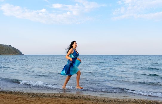 The woman runs on sea coast. A picturesque landscape
