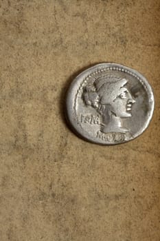 Ancient silver denauius coin on paper