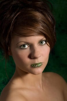 Woman with beautiful green eyes and little green diamonds on her lips