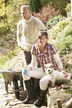 Couple With Dog Having Coffee Break Whilst Working Outdoors In G