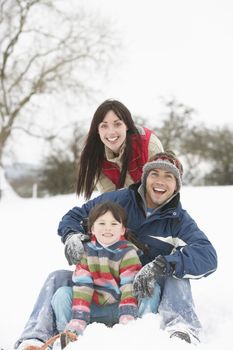 Family Having Fun In Snowy Countryside
