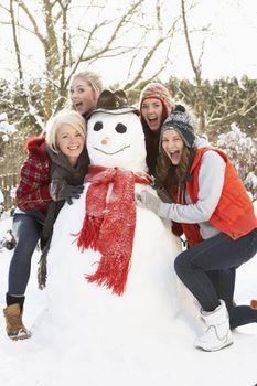 Group Of Teenage Girls Building Snowman
