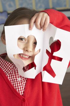Female Primary School Pupil Cutting Out Paper Shapes In Craft Le