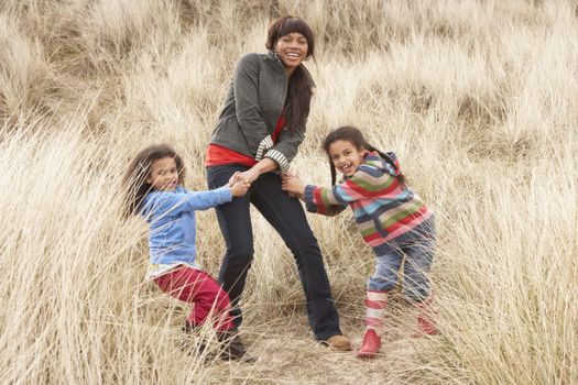 Mother And Daughters Having Fun In Sand Dunes