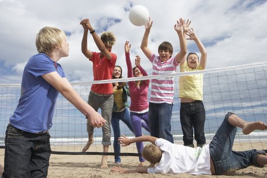 Teenagers playing volleyball