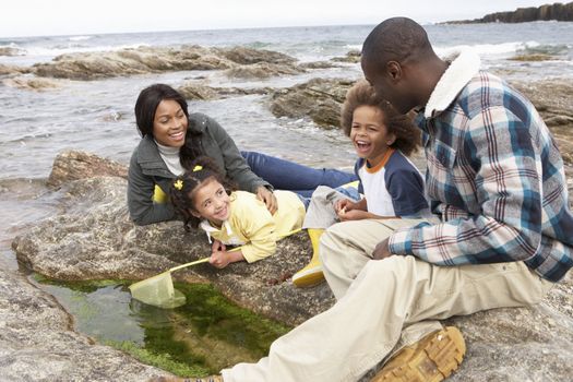 Young family with fishing net on rocks
