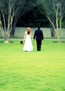 Bride and groom walking away, cross process, blur