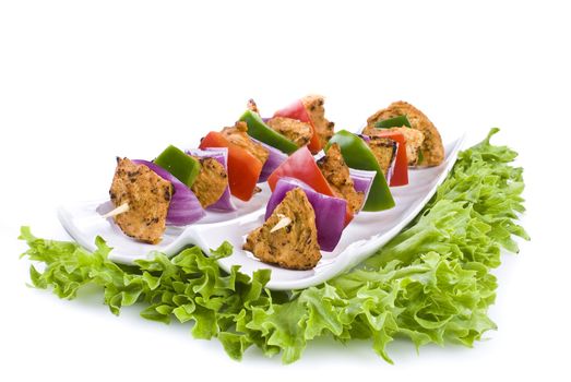 Skewers with chicken and vegetables on the plate - isolated