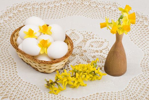 a basket of eggs, forsythia and yellow daffodils