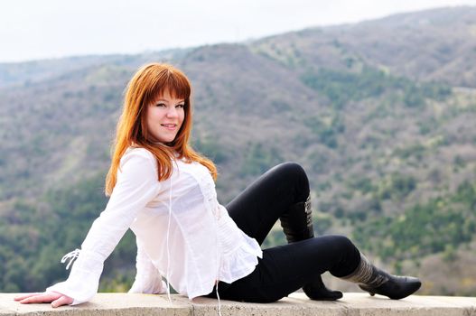  redheaded girl sitting on the wall
