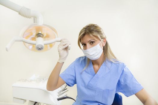 dental assistant adjusting the lamp 