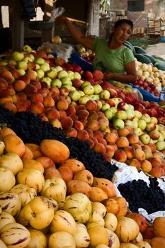 The Peruvian at a counter with fruit.