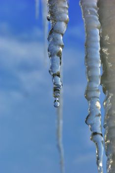 Icicles on the roof against the blue sky