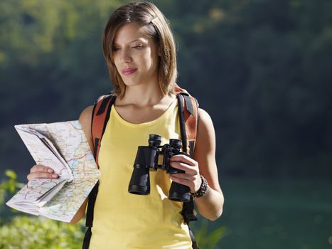 woman hiking with binoculars and map