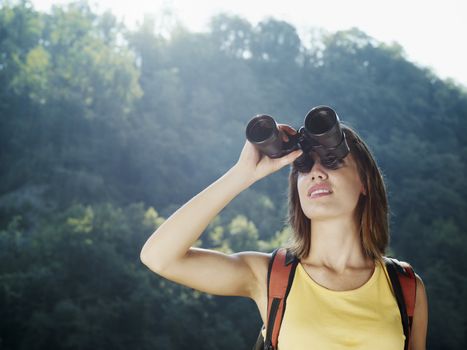 young woman hiking with binoculars 
