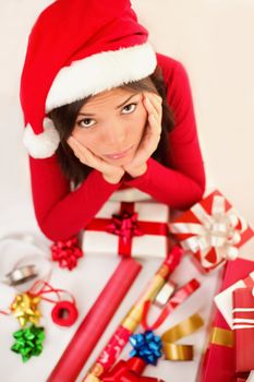 Sad christmas santa woman wrapping gifts