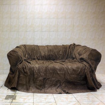 	Old brown textile couch in bathroom