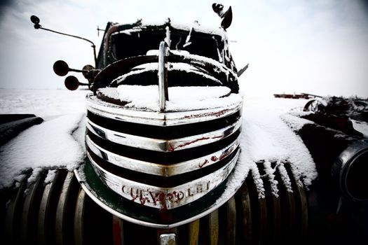 Frontend of an abandoned olf farm truck in winter