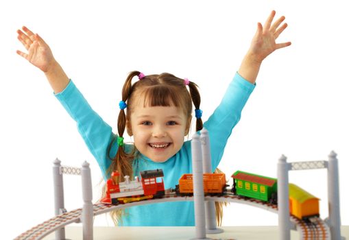 Joyful girl playing with toy railway