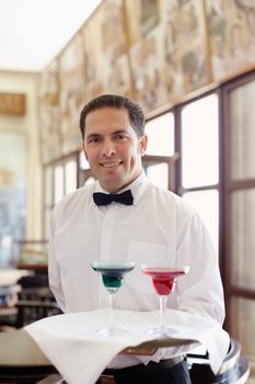 waiter standing with tray in restaurant
