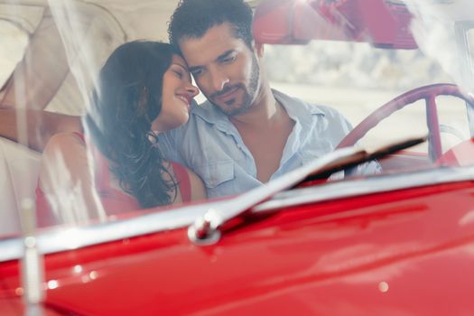 girlfriend and boyfriend flirting in red old car