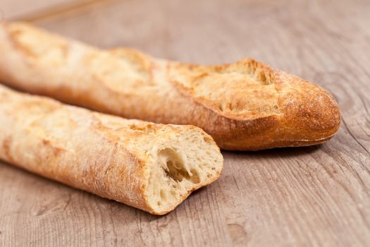 Fresh crusty baguette on wooden background