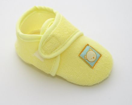 one babies shoe in a yellow towelling fabric