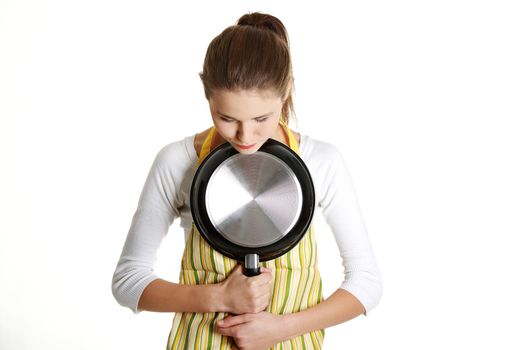 Worried female teen with a frying pan.