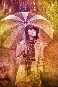 Girl with umbrella at park in rainy day.