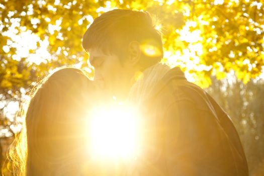 Couple kissing in the park at sunset